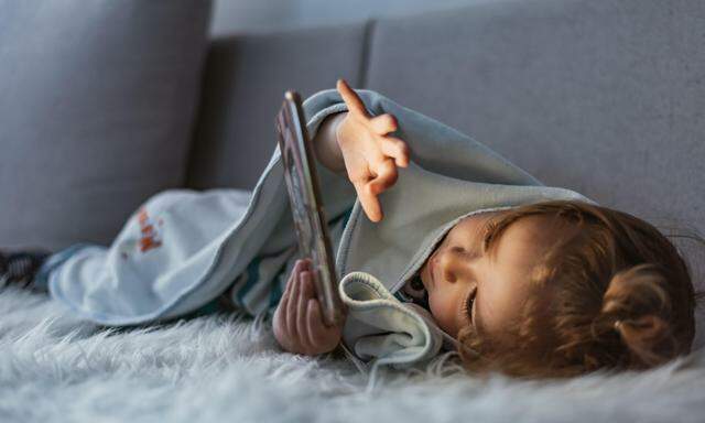 Das Baby kurz mit dem Smartphone abzulenken, ist verführerisch, kann aber langfristig Schaden anrichten. 
