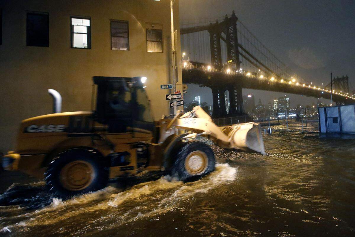 Brooklyn, New York. Ein Bagger fährt durch die überschwemmten Straßen des New Yorker Stadtteils.