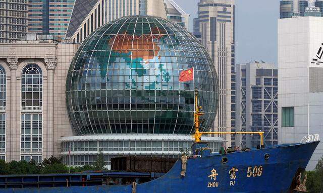Archivbild. Eine chinesische Flagge flattert auf einem Schiff vor einer Weltkugel in Shanghai, China.