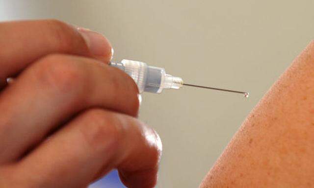 ARCHIV - Ein Arzt spritzt einer Patientin am 10. Oktober 2008 in Dresden zur Impfung ein Grippeschutz
