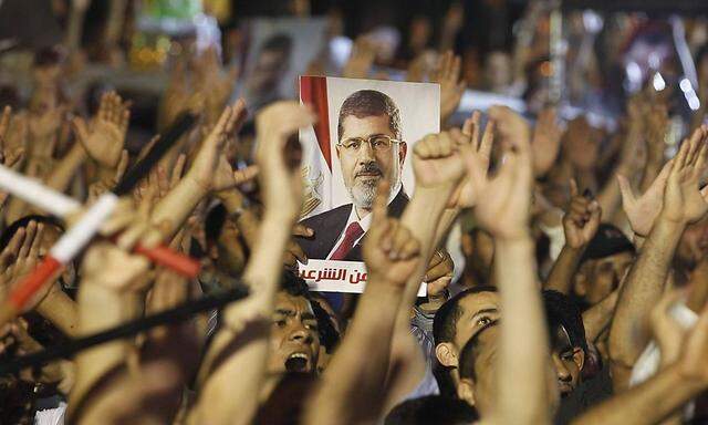 Members of the Muslim Brotherhood and supporter of ousted Egyptian President Mohamed Mursi shouts slogans at the Raba El-Adwyia mosque square in Cairo