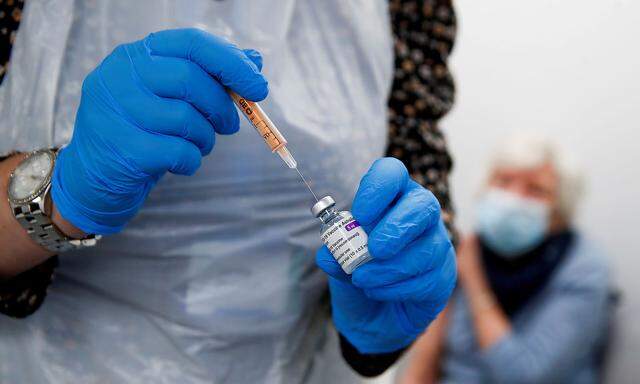 FILE PHOTO: A health worker fills a syringe with a dose of the Oxford/AstraZeneca COVID-19 vaccine