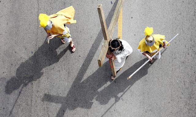 Salvador Zavala (C) as Jesus Christ carries the cross during the Via Crucis or Way of the Cross in Chicago on April 2,
