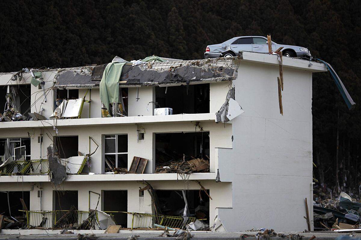 Donnerstag (24. März): Ein Auto, das vom Tsunami auf das Dach eines Gebäudes in Minamisanriku gespült wurde.