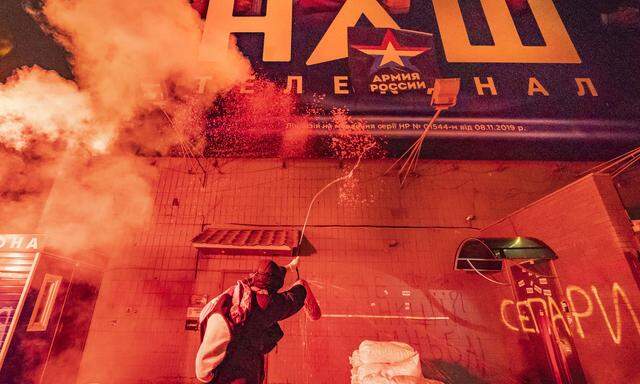 February 2, 2022, Kiev, Kiev, Ukraine: A protester throws paint to a banner of the tv channel NASH in its Kiev headquart