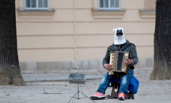 Ein Mann mit Pferdemaske in der Mariahilferstraße. Die Straßen leeren sich im Lockdown. An der Börse spielt die Musik weiter.
