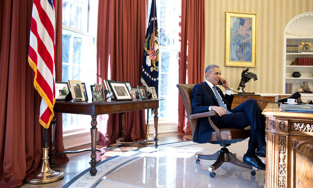 President Barack Obama talks on the phone with Alan Gross, who was en route to the United States from Cuba, in the Oval Office in this White House handout photo