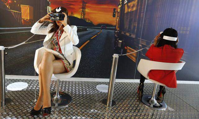 Women try out Samsung Gear VR devices during a showcase at the Mobile World Congress in Barcelona
