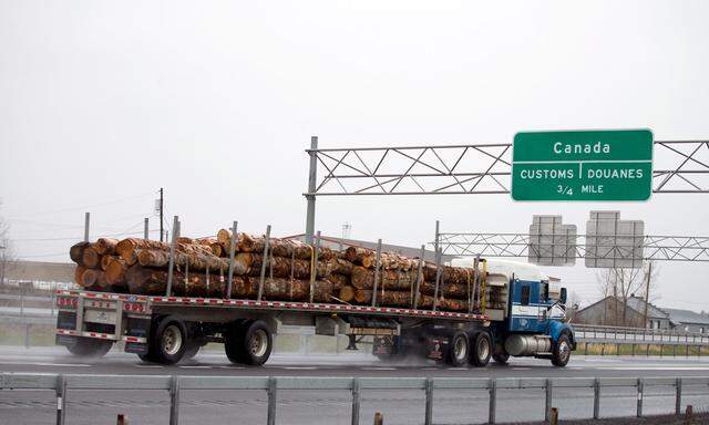 A truck carrying logs heads toward the Canada border in Champlain, New York