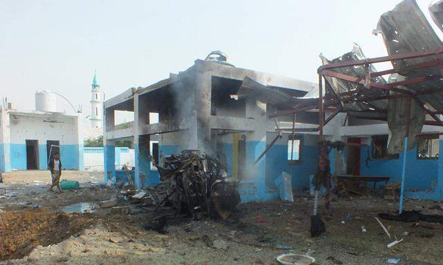 A dead body is seen at the site of a Saudi-led air strike on a hospital in Abs district