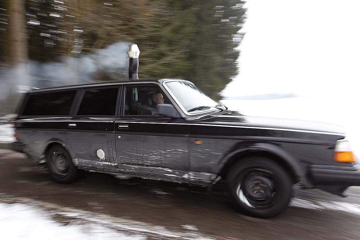 Volvo mit Holzofen. Dicker Rauch steigt aus dem zweiten Auspuff des schwarzen Volvo 240 des Schweizers Pascal Prokop: Um dem frostigen Winter standzuhalten ...