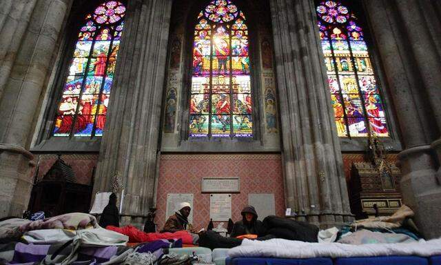 Refugees sit in a mattress camp in Votivkirche church in Vienna