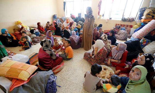 Civilians who fled their homes from the clashes on the outskirts of Falluja, gather in a school on the outskirt of Garma