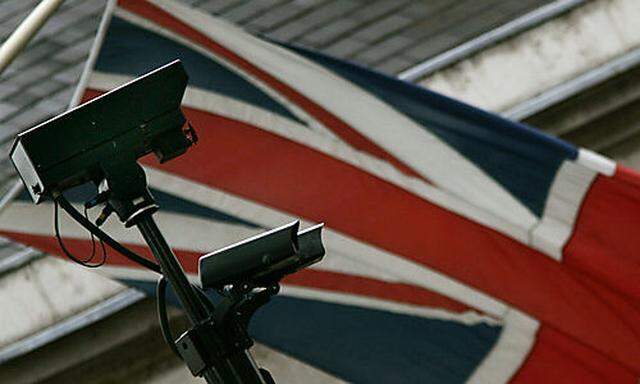 Backdropped by a British flag, closed-circuit surveillance cameras keep watch, in central London, Tue