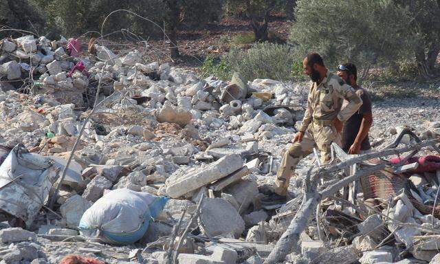 Rebel fighters from ´Jaysh al-Sunna´ inspect the damage at a weapons factory operated by them that was targeted in what activists say were U.S.-led air strikes on Atma village