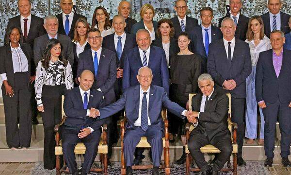 Präsident Rivlin (Mitte) schüttelt den beiden führenden Köpfen der Acht-Parteien-Koalition, Bennet (vorne links) und Lapid (vorne rechts), die Hand.