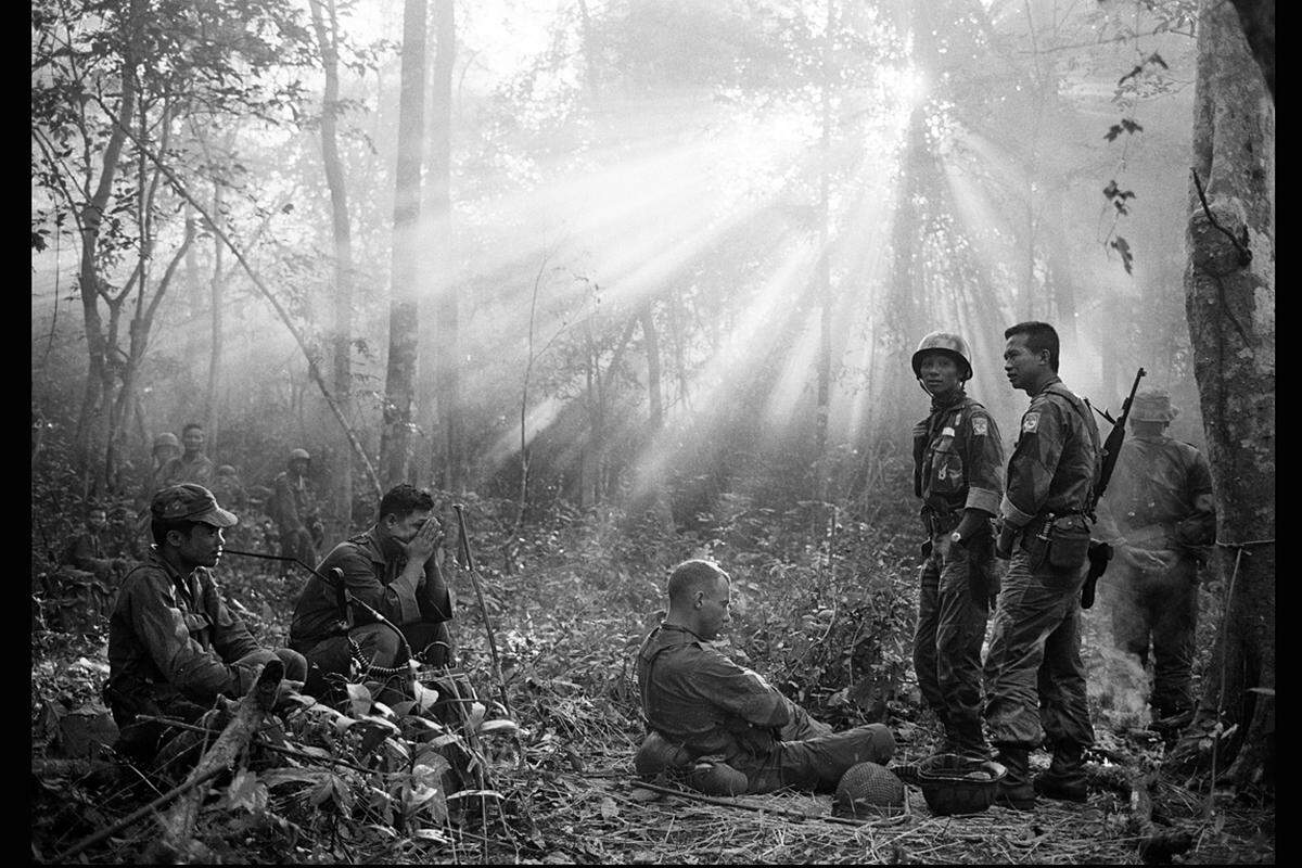 Vietnam, Jänner 1965. Eine südvietnamesische Truppe und ihre US-Begleiter ruhen sich nach einer langen Nacht im feuchtkalten Dschungel aus. Sie hatten sie einen Angriff der Vietkong erwartet, der aber ausblieb.