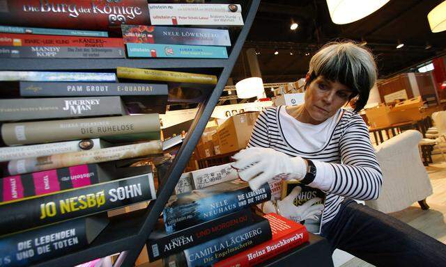 A woman sorts books at a booth during preparations for the upcoming book fair in Frankfurt