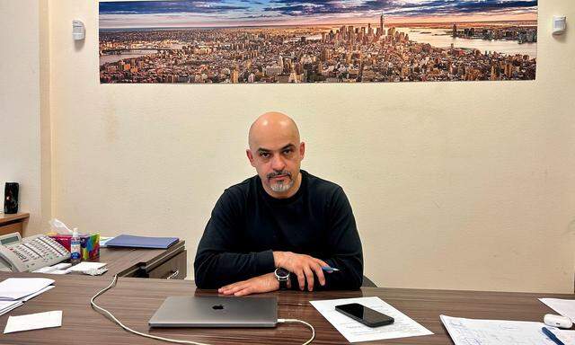 Mustafa Naiem mit einem Panorama von New York in seinem Büro.