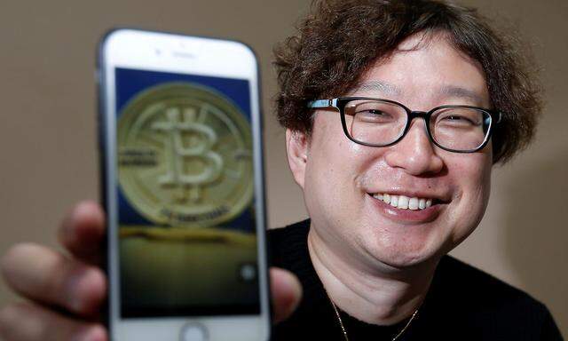 Ein japanischer Bitcoinhändler posiert mit seinem Smartphone. 