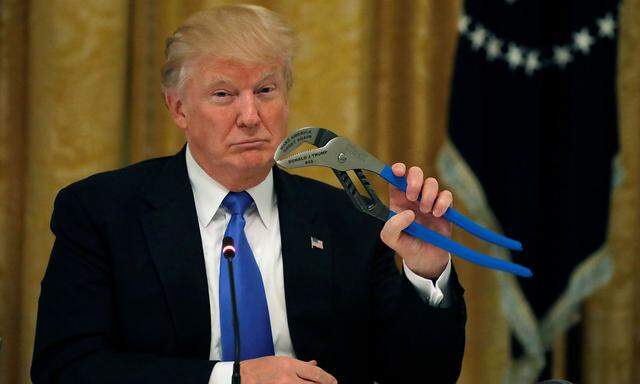 U.S. President Donald Trump holds a mechanical tool as he attends a Made in America roundtable in the East Room of the White House in Washington, U.S.