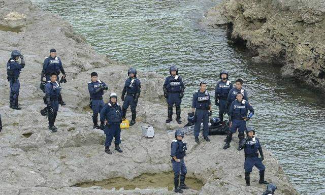 Japan Coast Guard officials are seen as they guard on a Uotsuri island, part of the disputed islands in the East China Sea, known as the Senkaku isles in Japan, Diaoyu islands in China