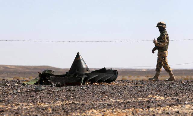 An Egyptian army soldier stands guard near debris from a Russian airliner which crashed at the Hassana area in Arish city