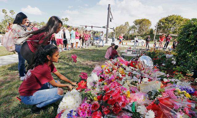 Bouquets are placed at a memorial on campus on the one year anniversary of the shooting which claimed 17 lives at Marjory Stoneman Douglas High School in Parkland