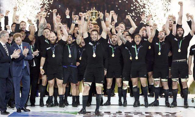 Prince Harry of Britain applauds as McCaw of New Zealand holds up the Webb Ellis trophy after winning the Rugby World Cup Final against Australia at Twickenham in London
