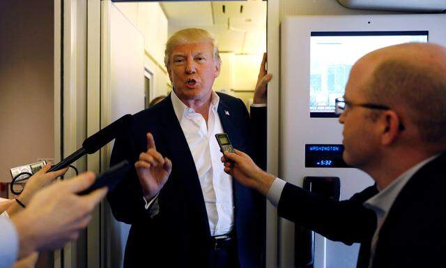 U.S. President Donald Trump speaks with reporters aboard Air Force One on his way to a ´Make America Great Again´ rally at Orlando Melbourne International Airport in Melbourne, Florida