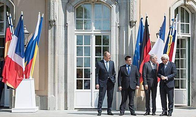 Männer mit Fahnen: Die Außenminister Russlands, der Ukraine, Frankreichs und Deutschlands (v. li.) in Berlin.