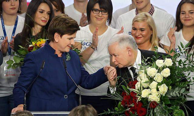 Parteichef Jaroslaw Kaczynski küsst seiner Spitzenkandidatin Beata Szydlo die Hand.