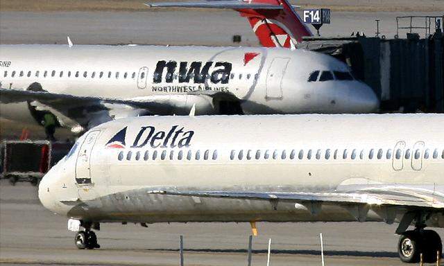 A Delta Airlines jet taxis past a Northwest Airlines jet parked at a gate at the Minneapolis St.Paul International Airport in Minnesota