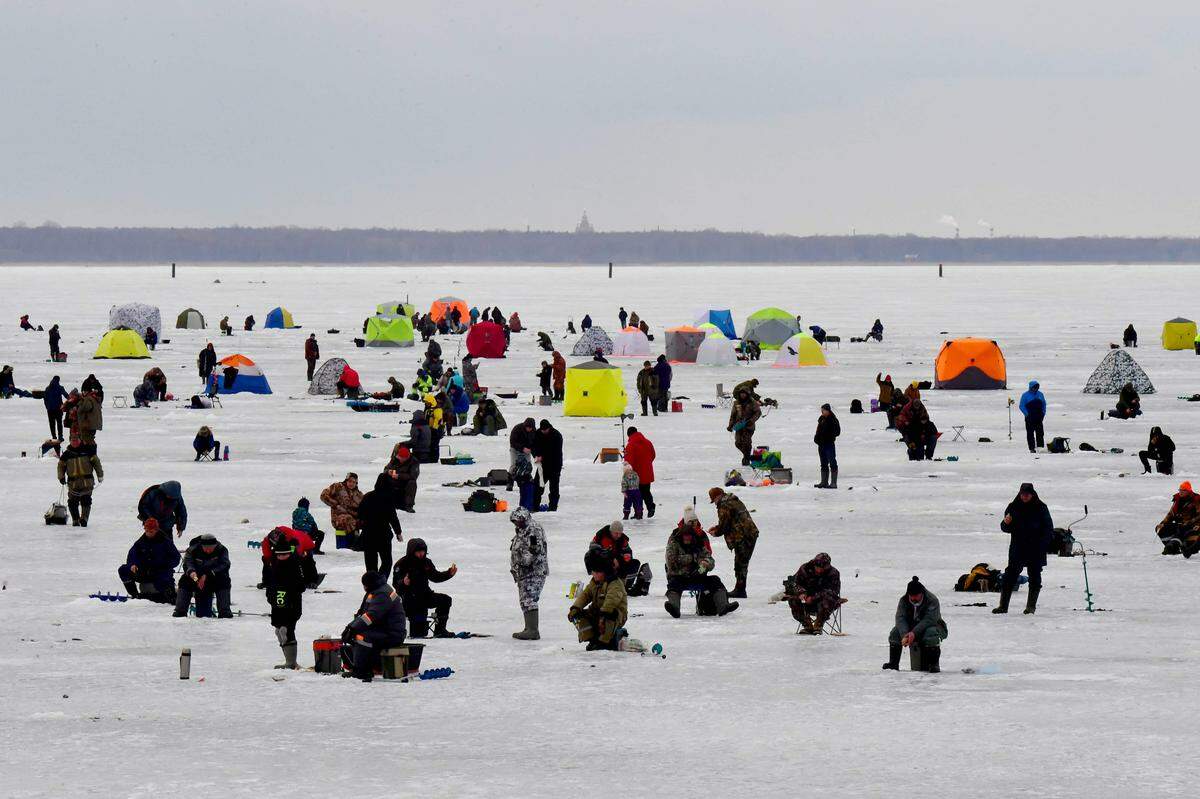 9. März. Russische Fischer fischen auf dem eisbedeckten Finnischen Meerbusen in Sankt Petersburg.