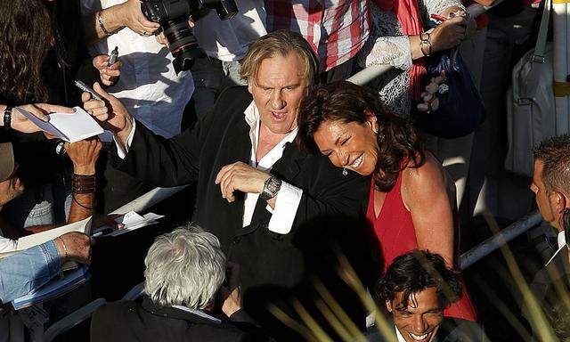 Actor Gerard Depardieu signs autographs to cinema fans as he arrives for the screening of the film ´United Passions´ at the 67th Cannes Film Festival in Cannes