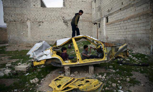 Symbolbild: Syrische Kinder spielen in einem Autowrack 