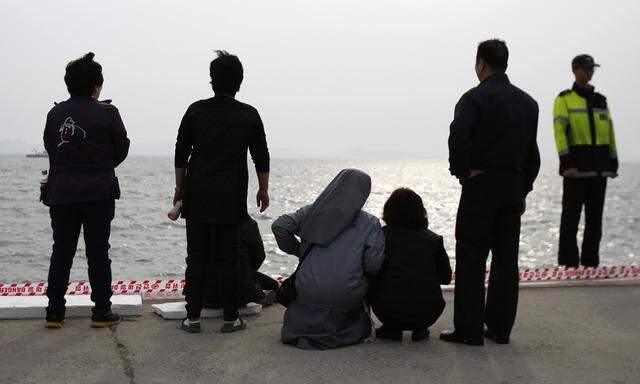 A family member (4th L) of a missing passenger on the South Korean ferry Sewol which sank in the sea off Jindo, escorted by a nun (3rd L), cries as she looks at the sea, at a port where family members of missing passengers gathered in Jindo