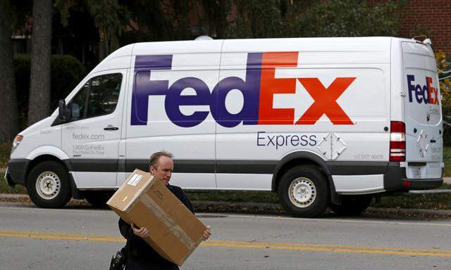 FILE PHOTO: A FedEx delivery worker carries a package for a delivery in Wilmette