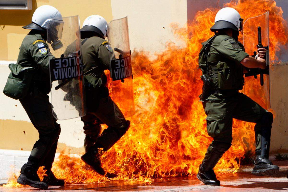 Jugendliche Demonstranten stecken in Griechenland mit Molotowcocktails das Gebäude einer Bank in Brand. Darin sterben drei Menschen.Die Nachricht von den Ausschreitungen schickt Euro und Börsen erneut auf Talfahrt.