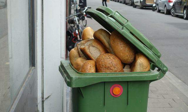 Altes Brot in einer Mülltonne vor einer Bäckerei in Antwerpen, Belgien.