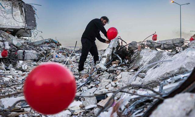 Ein „letztes Spielzeug“ für die getöteten Kinder. Der Türke Ogun Sever Okur befestigt in Antakya Ballons in den Ruinen.