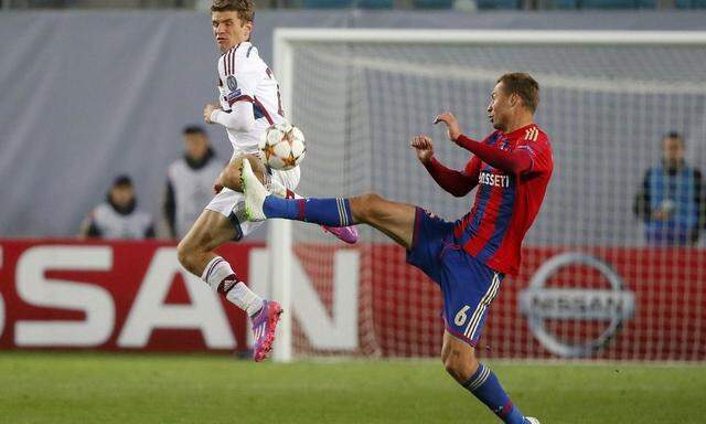CSKA Moscow's Aleksei Berezutski fights for the ball with Bayern Munich's Thomas Mueller during their Champions League soccer match at the Arena Khimki outside Moscow