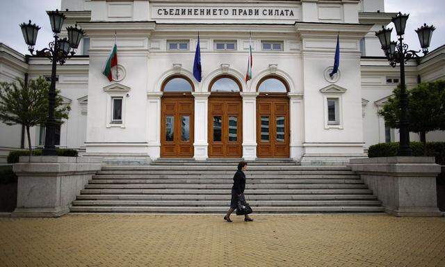 Woman walks past the parliament building in Sofia