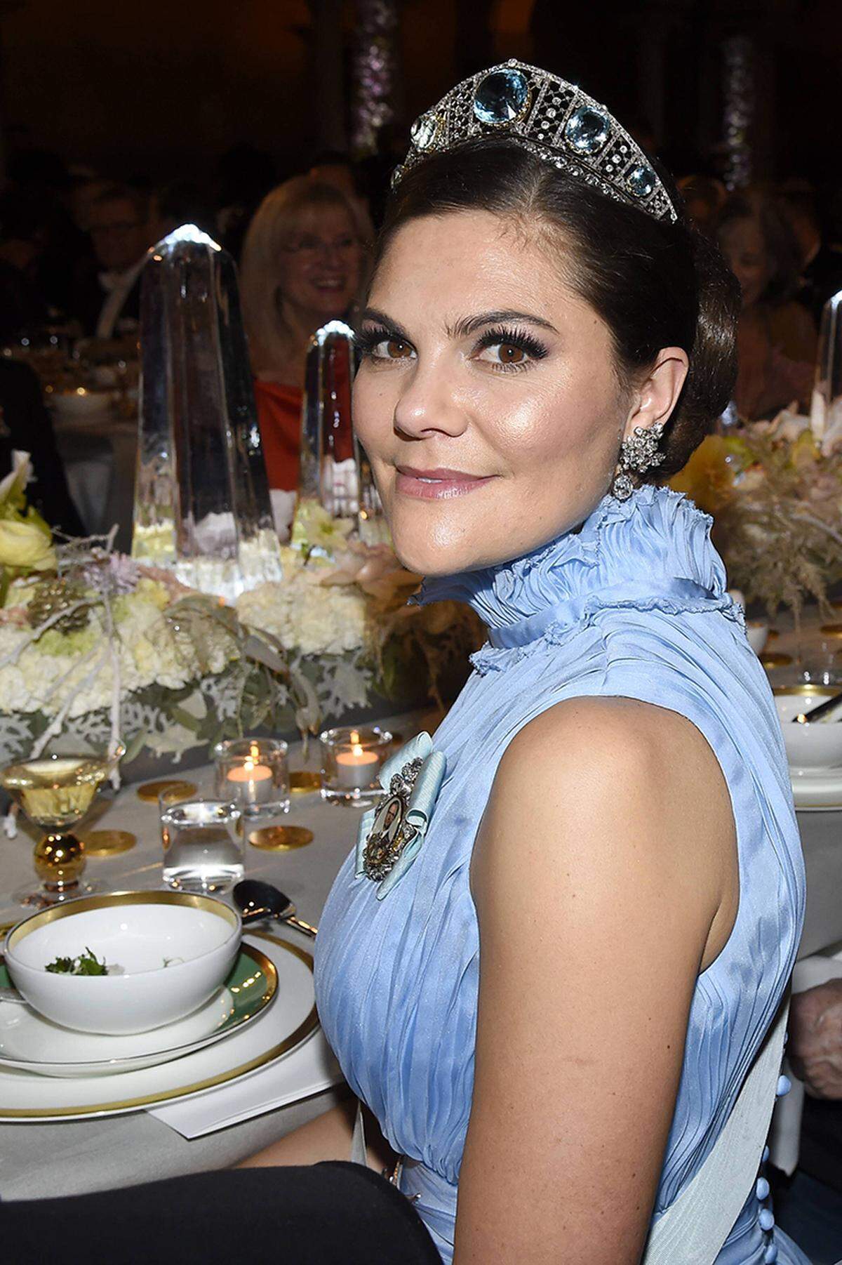 Vielleicht lässt Kronprinzessin Victoria deswegen lieber den Mund beim Close-up-Foto am Dînertisch halb zu? Vorbeugend, quasi? Der Hingucker blieb somit die Aquamarin-Tiara im Kokoschnik-Stil - ein Familienerbstück, das aus dem Erbe von Victorias Urgroßmutter Kronprinzessin Margaret kommt. Auch die Ohrringe mit floralem Motiv stammen aus der Familie - aus Königin Silvias Schatzkästchen, um genau zu sein.