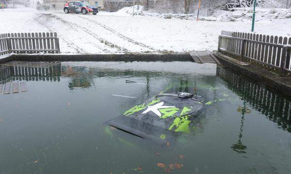 Der Blick in den Teich zeigt keinen Fisch, sondern ein Rallyeauto.