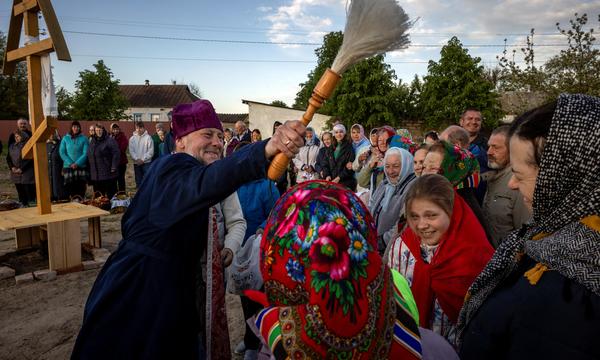 Ein Priester segnet Feiernde zum Orthodoxen Osterfest in der Ukraine.