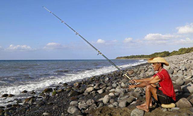 A man fishes on the Jamaique beach in Saint-Denis on the French Indian Ocean island of La Reunion
