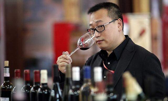 File photo of a man smelling a glass of red wine from Italy's Rosso Vino vineyard during the he 6th Shanghai International Wine Trade Fair