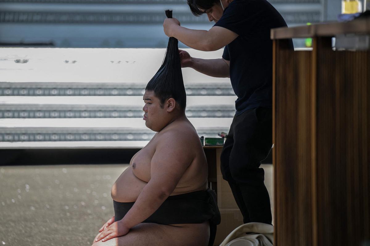 15. April. Ein Sumoringer lässt sein Haar zu einem Haarknoten frisieren, bevor er am jährlichen „honozumo“ teilnimmt, einer feierlichen eintägigen Sumo-Vorführung für Zuschauer am Yasukuni-Schrein in Tokio.