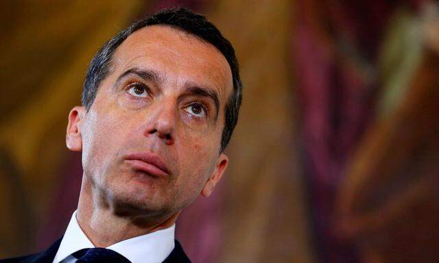 Austrian Chancellor Kern listens during a news conference after a cabinet meeting in Vienna